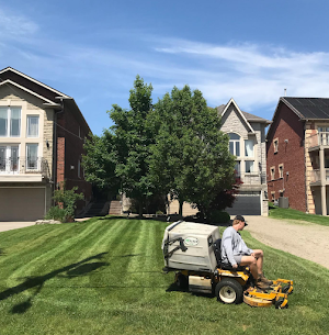 Crew mowing a striped residential lawn in Mississauga